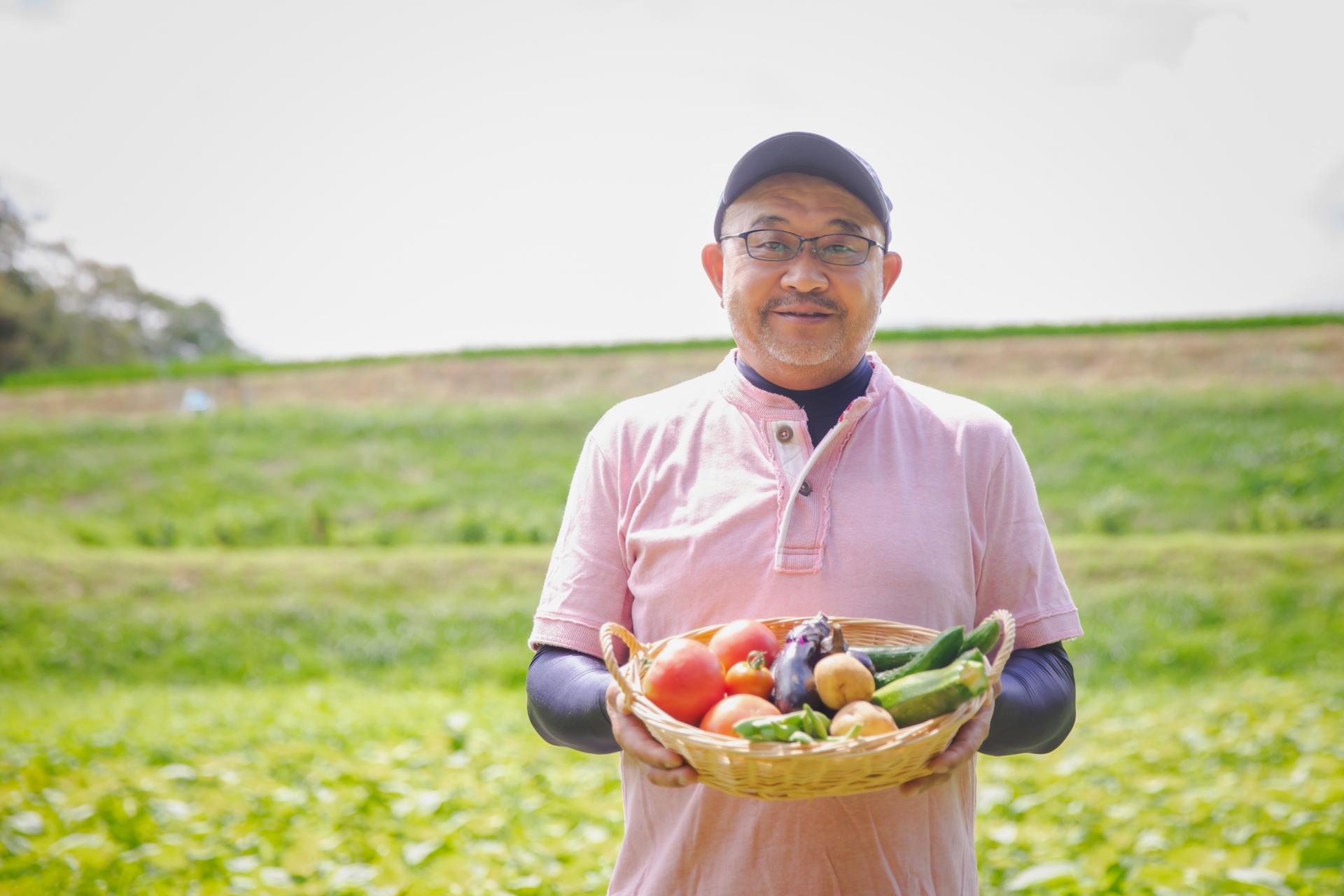 畑で野菜を持った男性